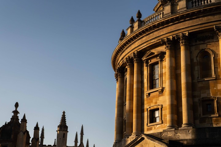 Close-up of a historic building with columns and spires under a clear blue sky.